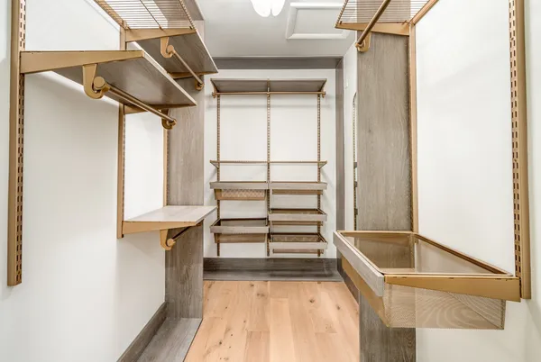 a view of walk in closet with empty racks