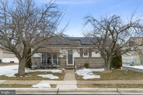 a front view of a house with garden and trees