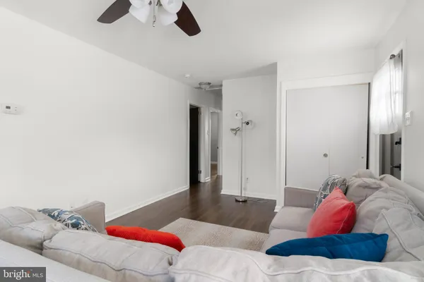 a living room with furniture and a ceiling fan