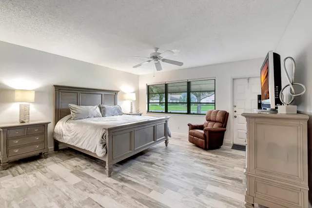 a bedroom with a large bed and a flat tv screen