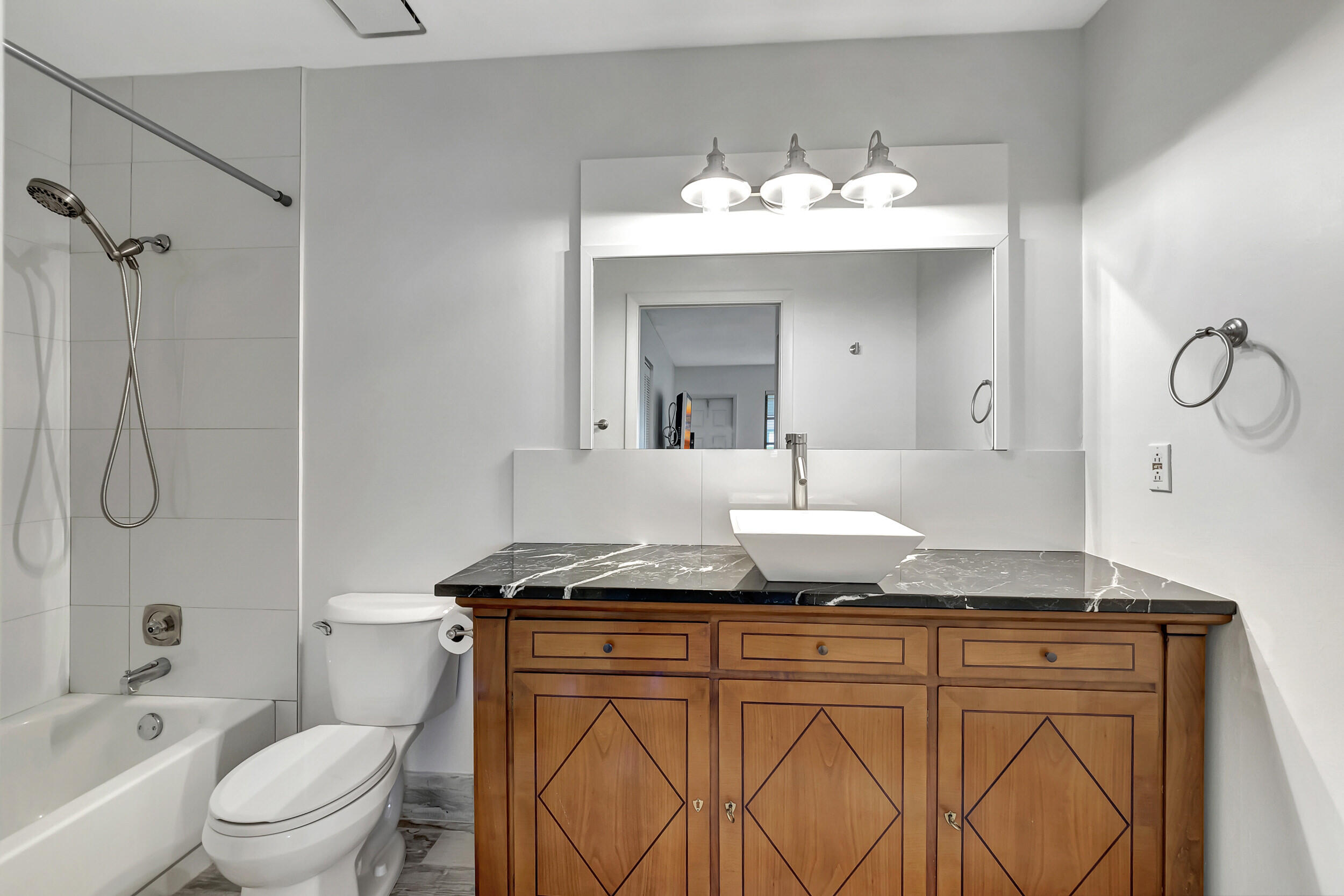 14040 Nesting Way, Unit B Delray Beach, FL 33484 - Photo 22 of 26 a bathroom with a granite countertop sink vanity mirror and toilet