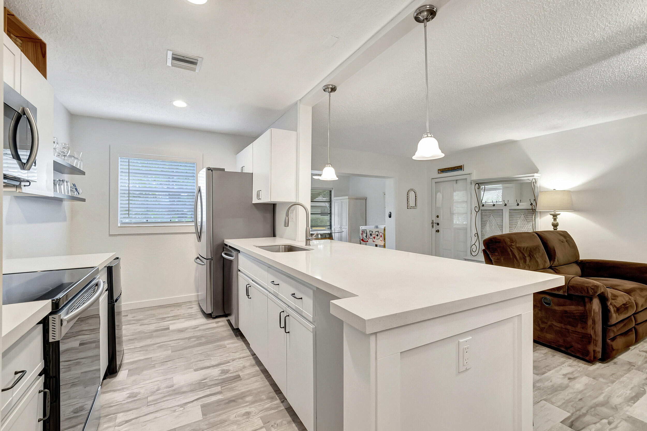 14040 Nesting Way, Unit B Delray Beach, FL 33484 - Photo 6 of 26 a large white kitchen with a stove a sink a refrigerator and a fireplace