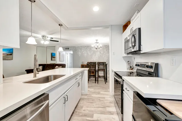 a kitchen with stainless steel appliances granite countertop a sink and dishwasher with white cabinets