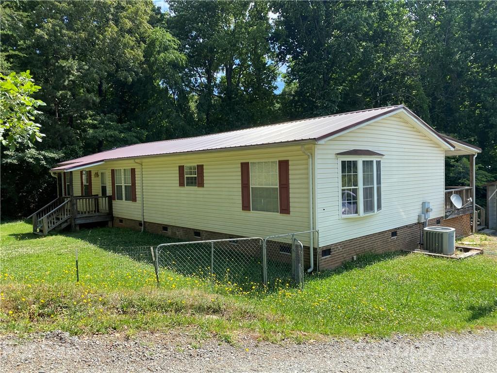 7596 Lowesville Meadows Road Stanley, NC 28164 - Photo 2 of 23 a backyard of a house with plants and large tree