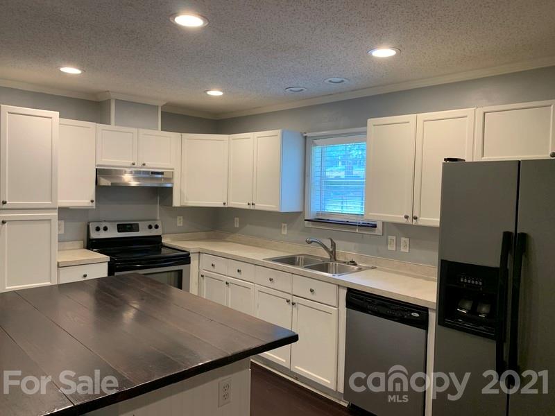 7596 Lowesville Meadows Road Stanley, NC 28164 - Photo 3 of 23 a kitchen with stainless steel appliances granite countertop a sink stove and refrigerator