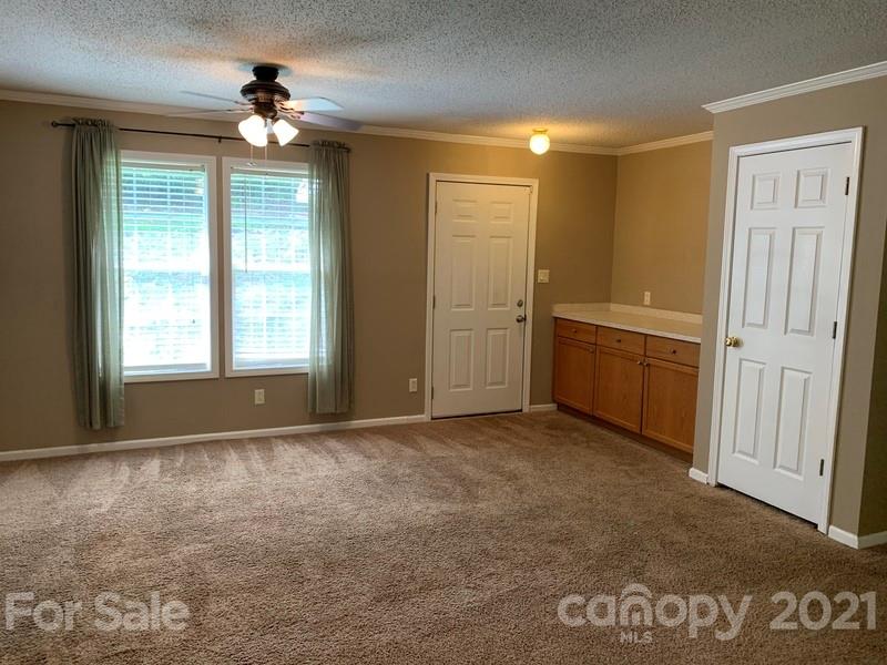 7596 Lowesville Meadows Road Stanley, NC 28164 - Photo 9 of 23 an empty room with windows and fan