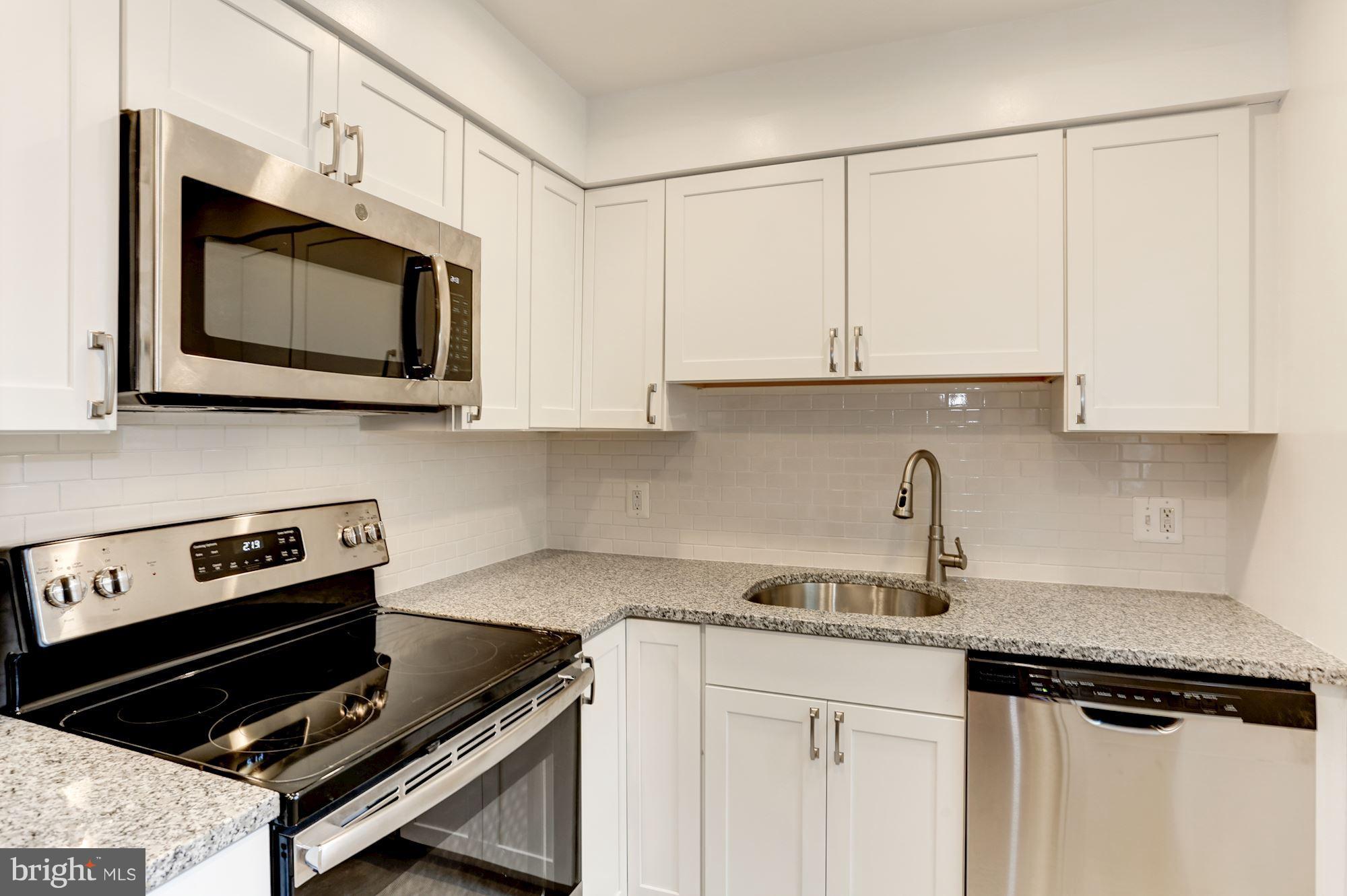 4608 31st Road South, Unit B2 Arlington, VA 22206 - Photo 2 of 29 a kitchen with stainless steel appliances granite countertop a sink stove and microwave