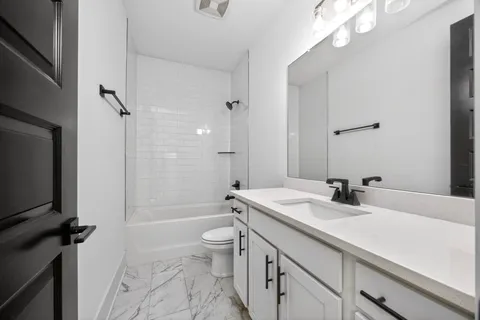 a bathroom with a sink a toilet a mirror and shower