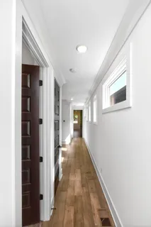 a view of a hallway with wooden floor and staircase
