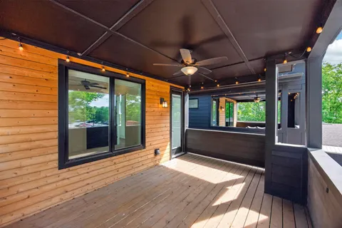 a view of an empty room with wooden floor and a large window