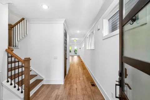 a view of a hallway with wooden floor and staircase