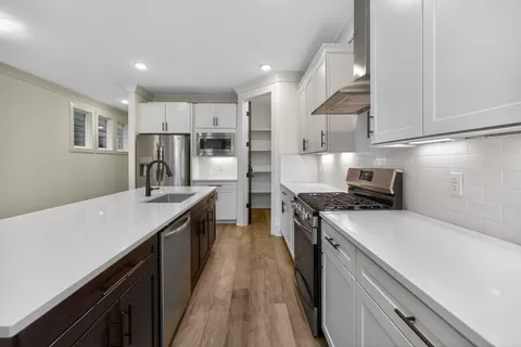 a kitchen with a sink a stove oven a counter top space and cabinets
