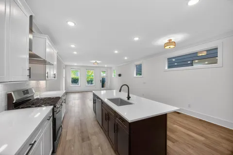 a kitchen with a sink cabinets and wooden floor