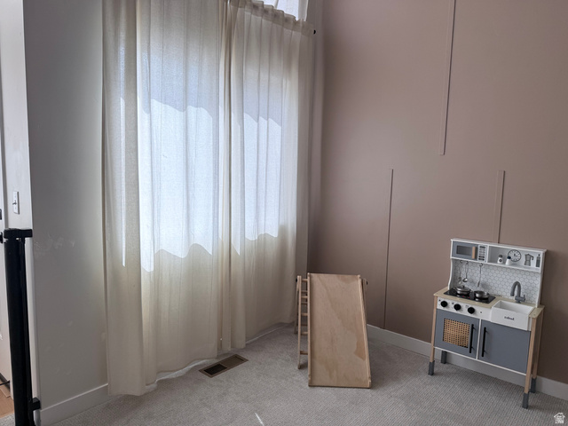 774 West 480 South American Fork, UT 84003 - Photo 53 of 76 Room featuring plush carpet flooring, a large window with full-length draperies, an accent wall with vertical paneling, and neutral-toned paint finishes