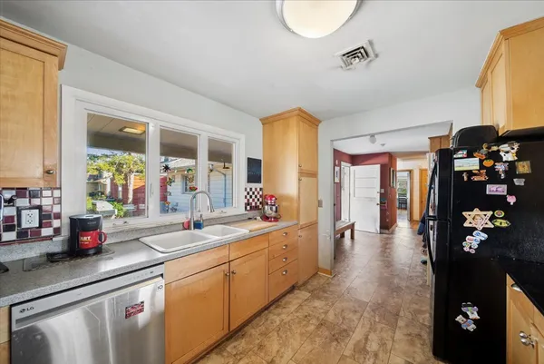 a large white kitchen with stainless steel appliances granite countertop a lot of counter space and a window