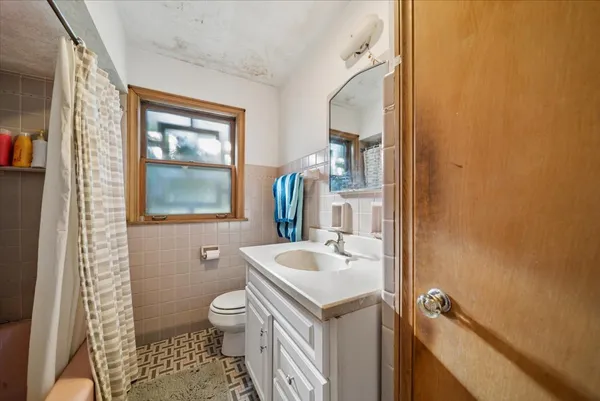 a bathroom with a toilet sink and mirror