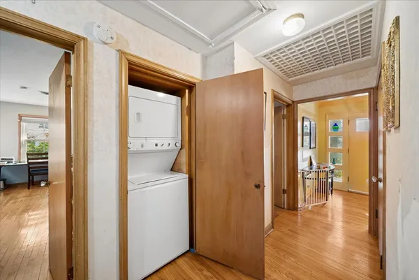 a view of a hallway with bathroom and wooden floor