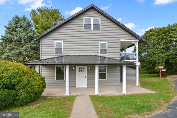 a front view of a house with a garden and plants