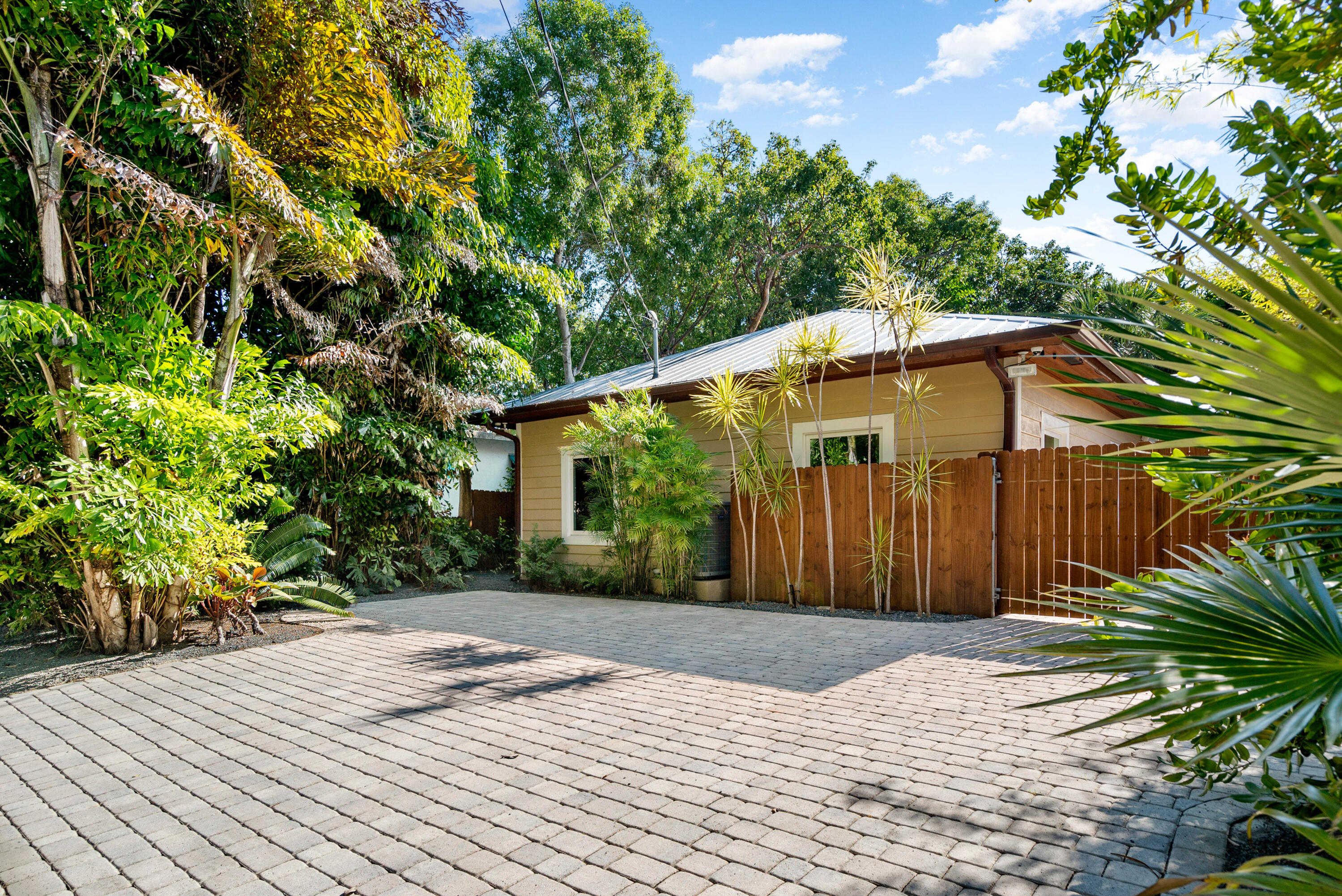 85 Henry Morgan Drive Key Largo, FL 33037 - Photo 24 of 40 a backyard of a house with large trees and wooden fence