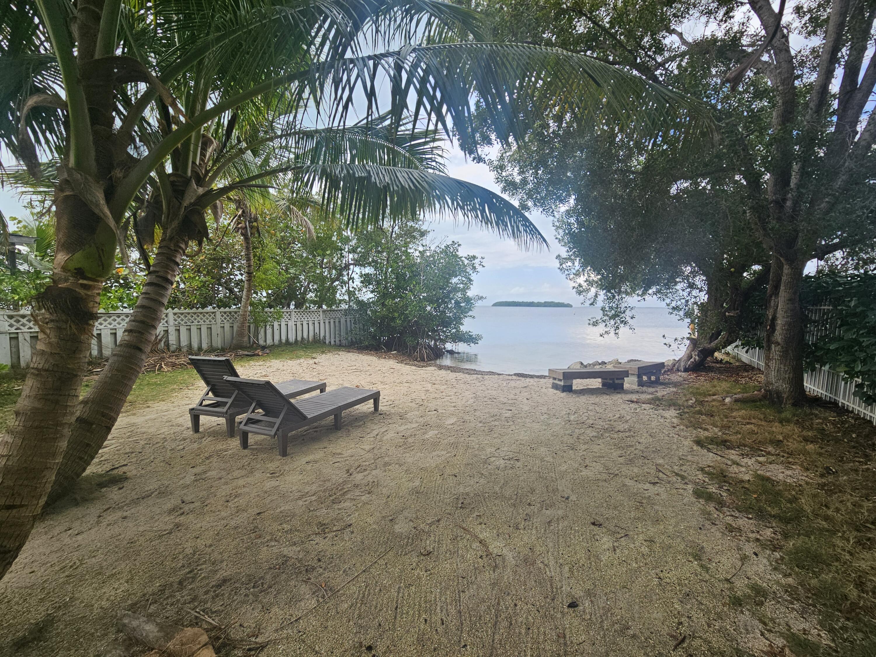 85 Henry Morgan Drive Key Largo, FL 33037 - Photo 31 of 40 a view of a bench in the backyard of a house