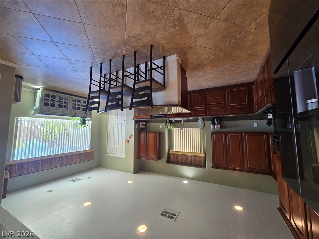 2567 Dirleton Place Henderson, NV 89044 - Photo 9 of 67 A well-equipped kitchen space features rich wood cabinetry and tile flooring.