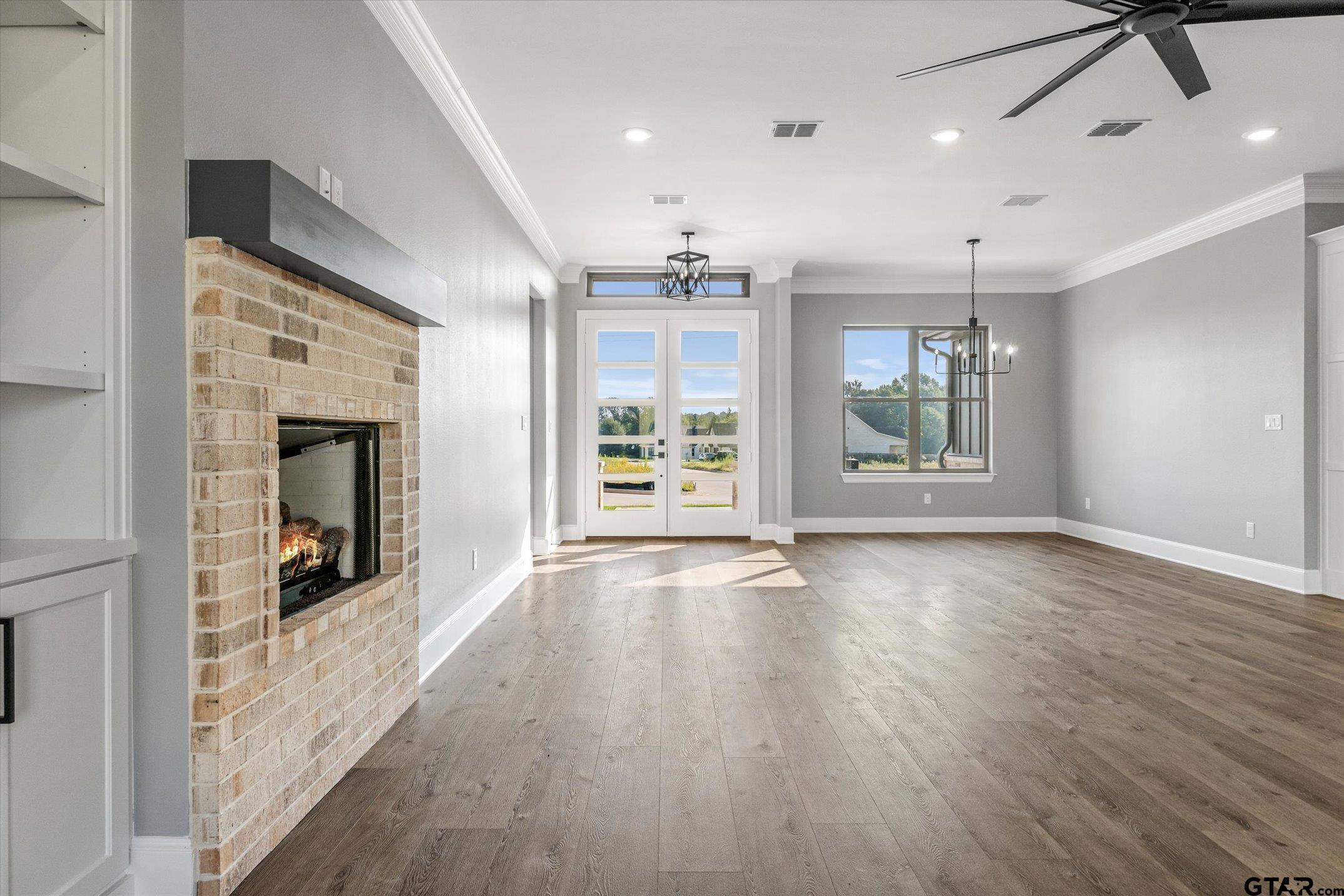 403 Sides Bullard, TX 75757 - Photo 11 of 33 an empty room with wooden floor chandelier and windows