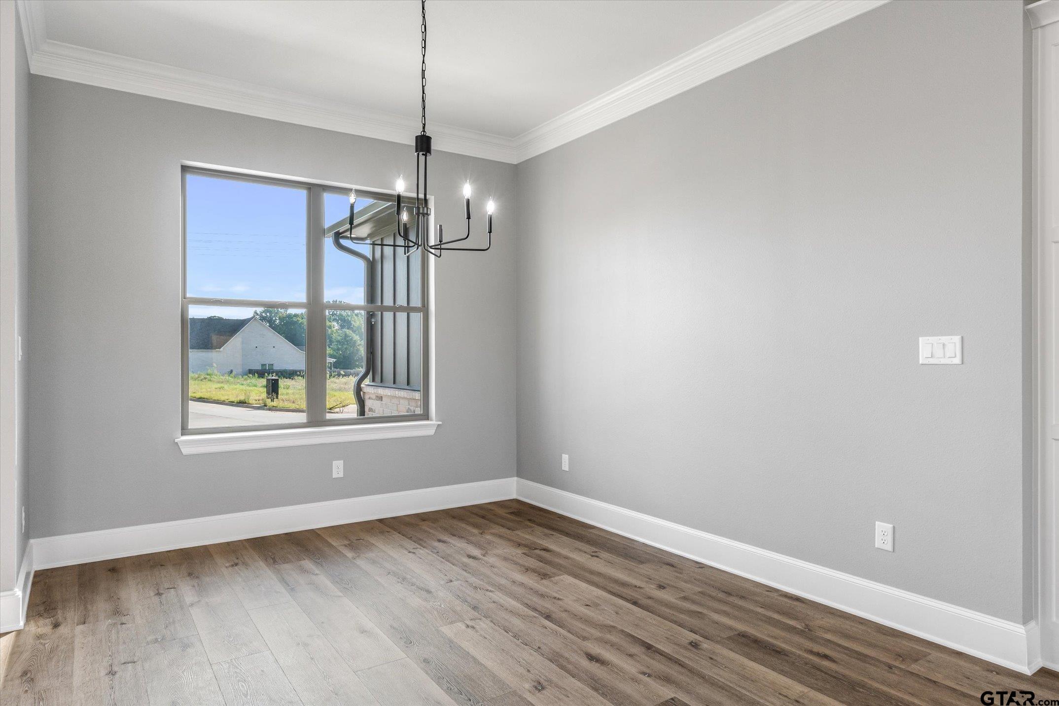 403 Sides Bullard, TX 75757 - Photo 23 of 33 an empty room with wooden floor chandelier and windows