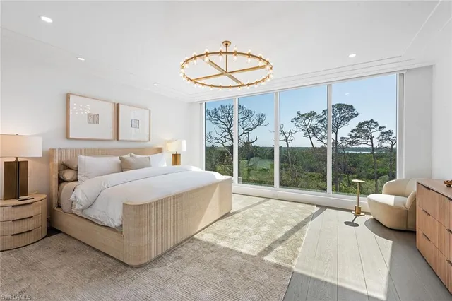 a spacious bedroom with a bed and a large window