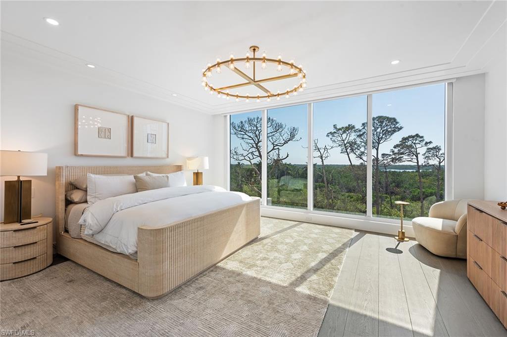 13945 Old Coast Road, Unit 406 Naples, FL 34110 - Photo 12 of 46 a spacious bedroom with a bed and a large window