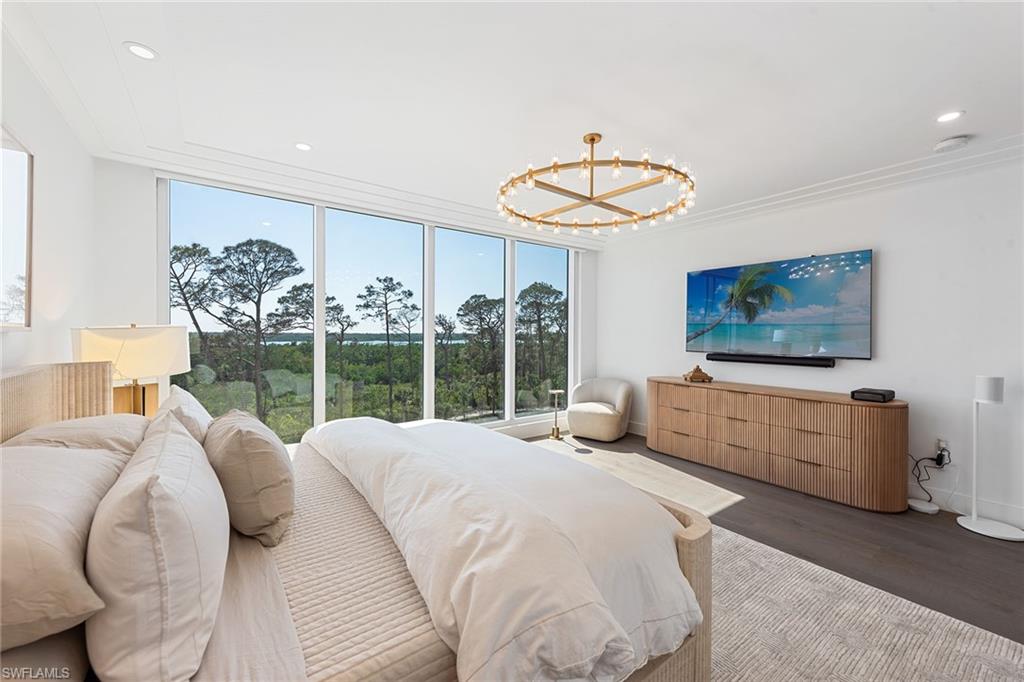 13945 Old Coast Road, Unit 406 Naples, FL 34110 - Photo 13 of 46 a bedroom with furniture and a large window