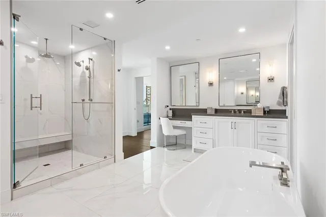 a large white bathroom with a granite countertop sink mirror and shower