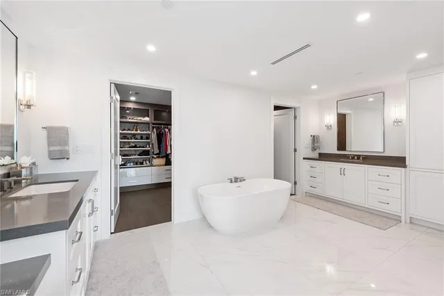 a spacious bathroom with a bathtub sink and mirror