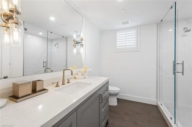 a bathroom with a sink a toilet and shower