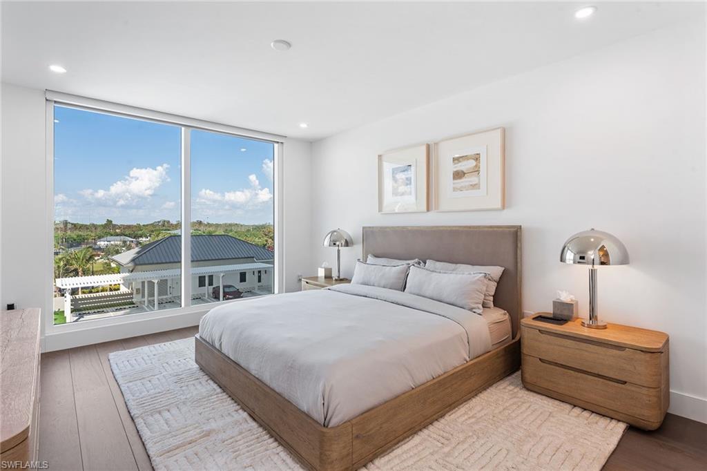 13945 Old Coast Road, Unit 406 Naples, FL 34110 - Photo 18 of 46 a bedroom with a large bed and a large window