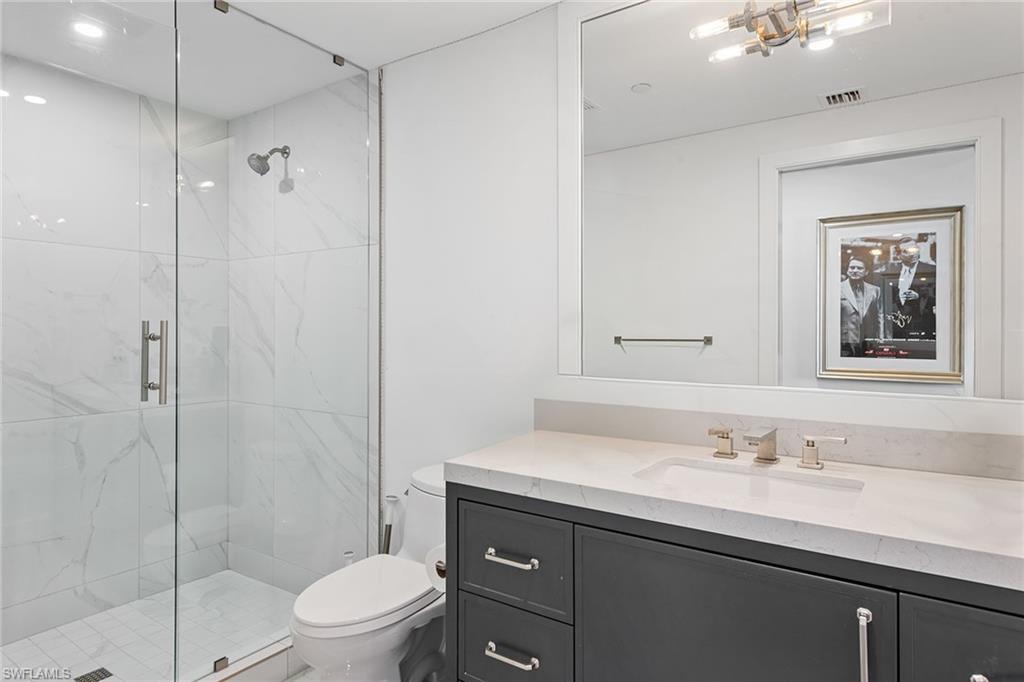 13945 Old Coast Road, Unit 406 Naples, FL 34110 - Photo 19 of 46 a bathroom with a sink a toilet and shower