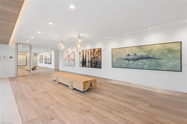a view of an empty room with wooden floor and a rug