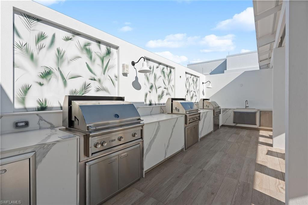 13945 Old Coast Road, Unit 406 Naples, FL 34110 - Photo 29 of 46 a kitchen with stainless steel appliances a stove a sink and a refrigerator