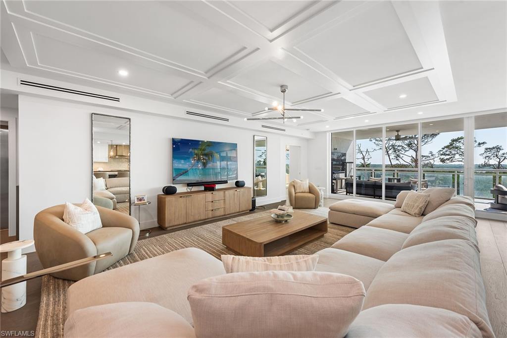 13945 Old Coast Road, Unit 406 Naples, FL 34110 - Photo 3 of 46 a living room with furniture a rug and a large window
