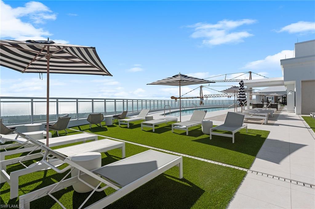 13945 Old Coast Road, Unit 406 Naples, FL 34110 - Photo 32 of 46 a view of a swimming pool with outdoor seating and plants