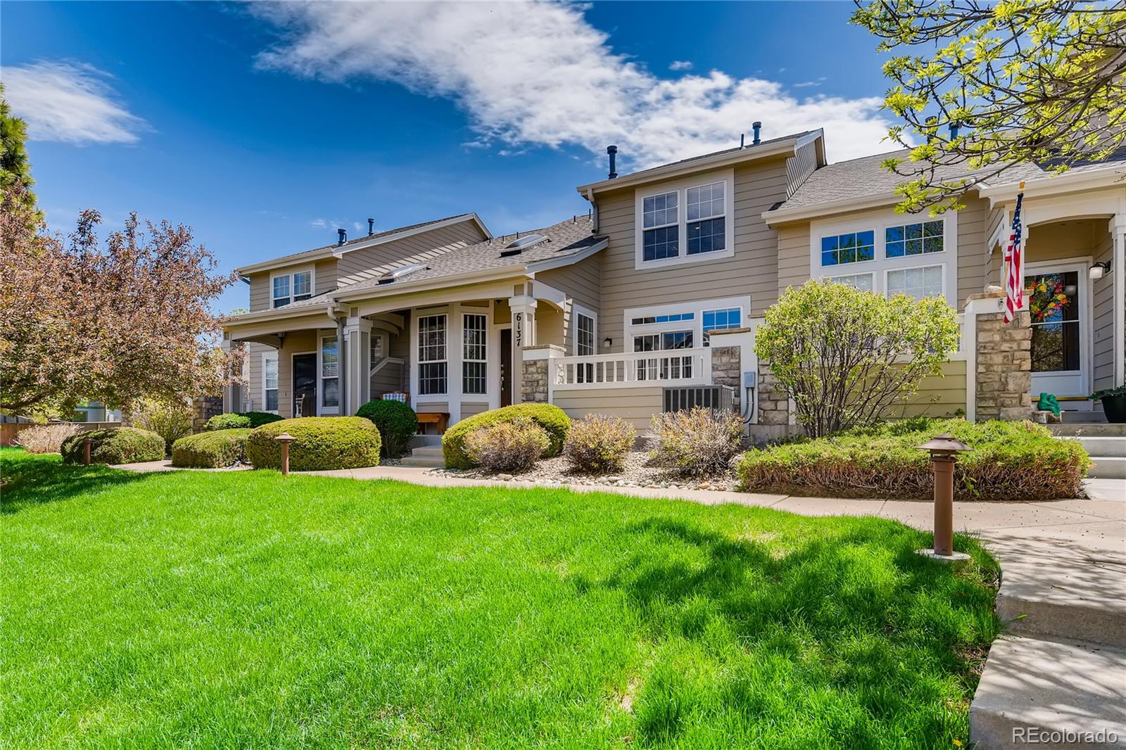 a view of a house with a yard and potted plants
