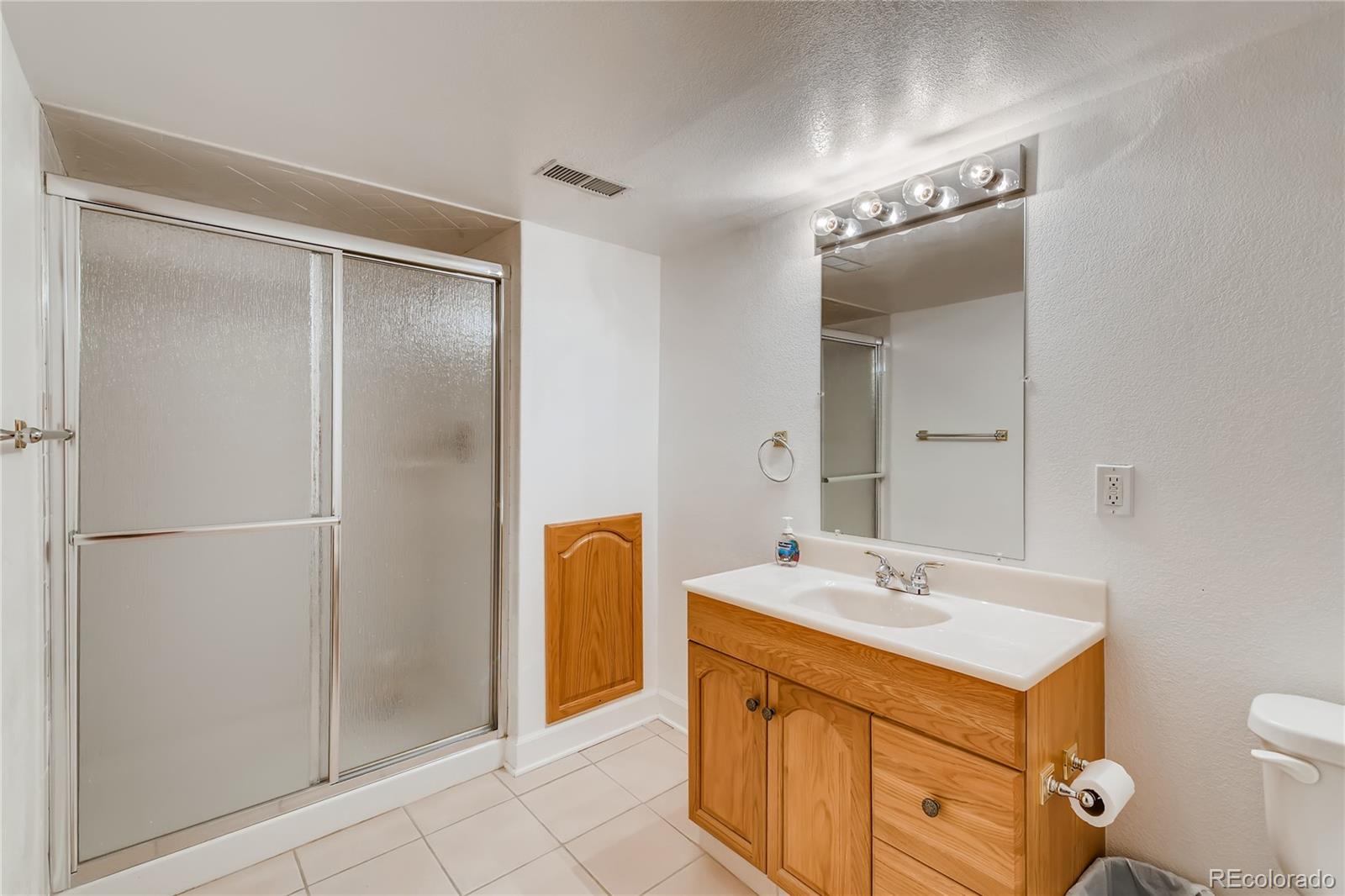 6137 Trailhead Road Highlands Ranch, CO 80130 - Photo 22 of 27 a bathroom with a sink mirror vanity and toilet