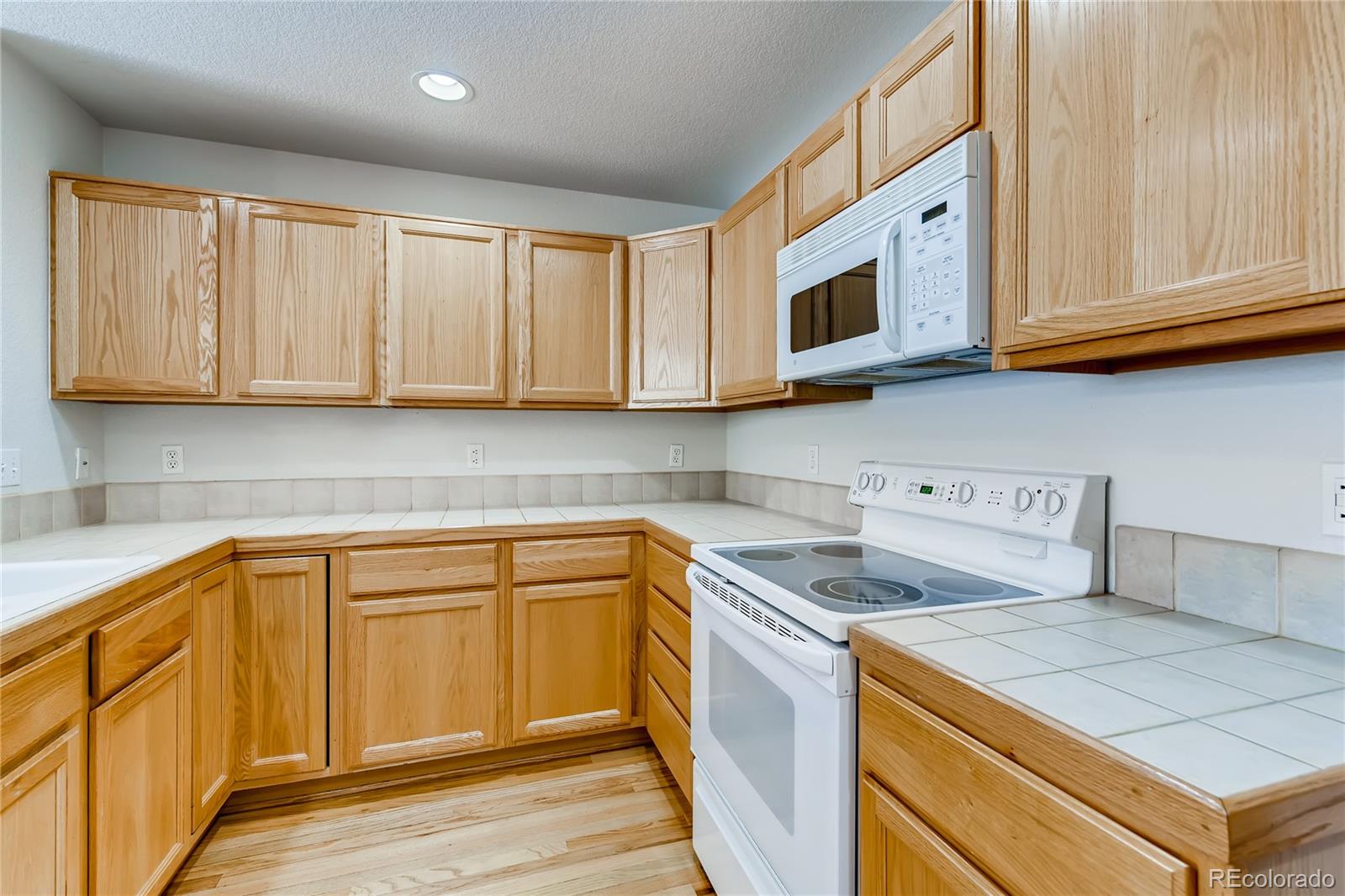 6137 Trailhead Road Highlands Ranch, CO 80130 - Photo 6 of 27 a kitchen with stainless steel appliances granite countertop white cabinets sink and a granite counter top