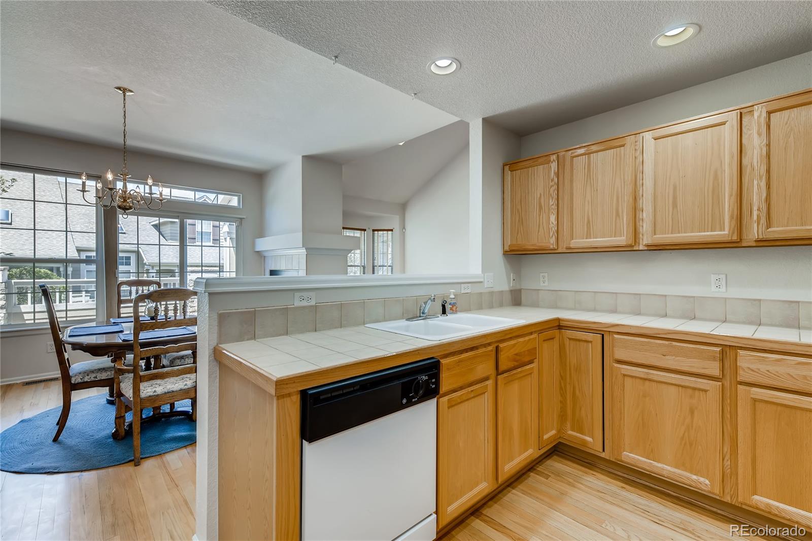 6137 Trailhead Road Highlands Ranch, CO 80130 - Photo 7 of 27 a kitchen that has a sink a stove counter top space and cabinets