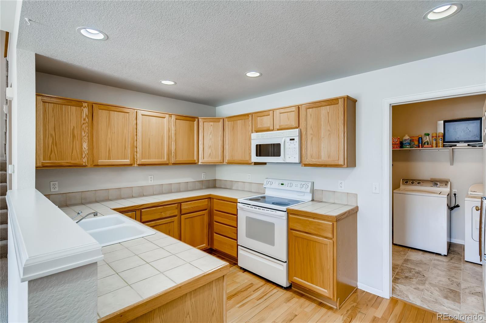 6137 Trailhead Road Highlands Ranch, CO 80130 - Photo 8 of 27 a kitchen with stainless steel appliances granite countertop a sink stove and refrigerator