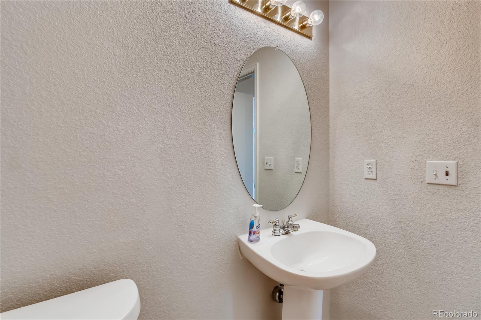 6137 Trailhead Road Highlands Ranch, CO 80130 - Photo 9 of 27 a bathroom with a toilet sink and mirror
