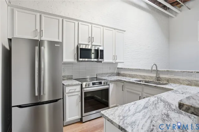 a kitchen with stainless steel appliances granite countertop a refrigerator sink and stove