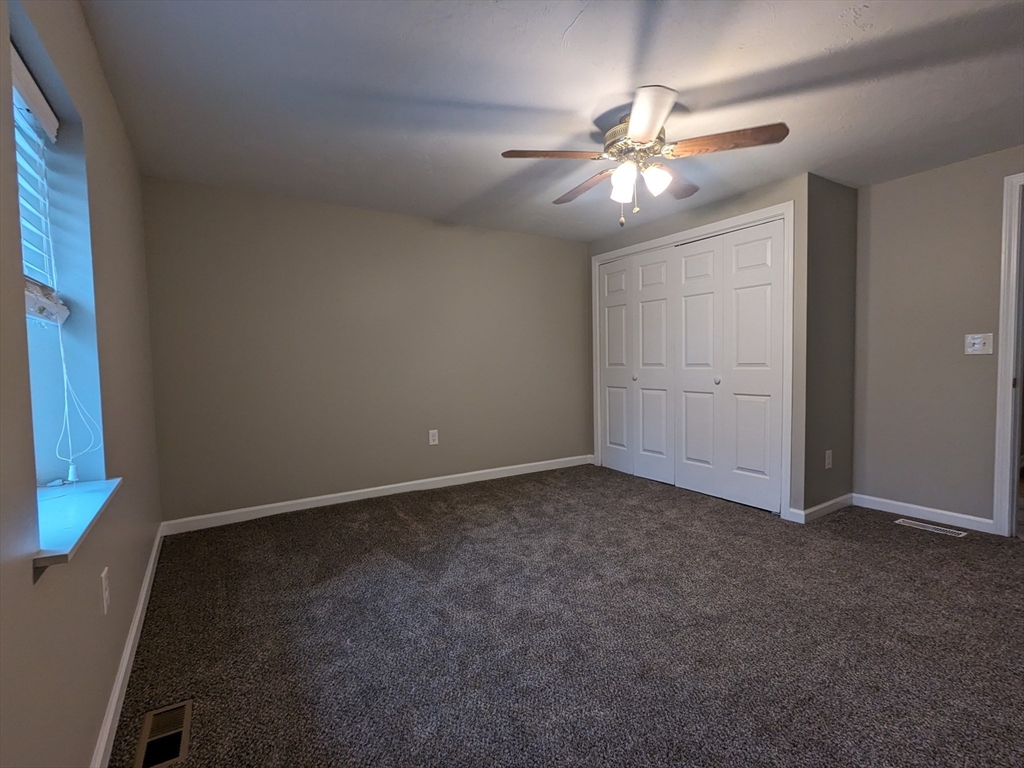 16 Hartness Road, Unit A Sutton, MA 01590 - Photo 12 of 18 an empty room with closet and fan