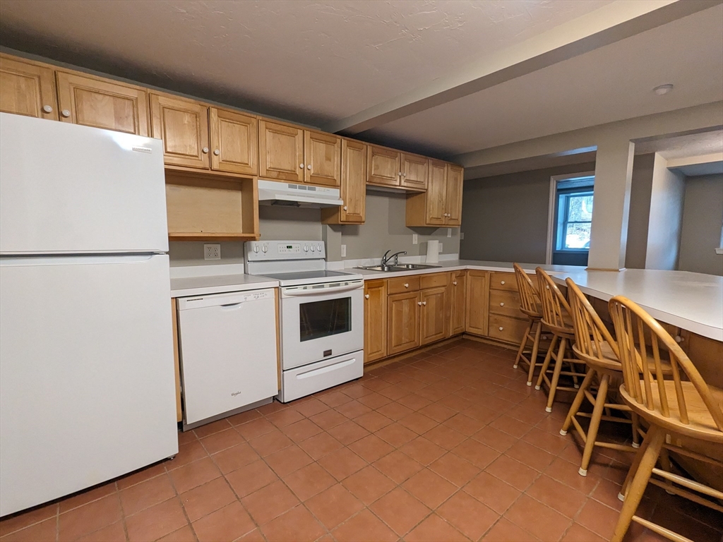 16 Hartness Road, Unit A Sutton, MA 01590 - Photo 2 of 18 a kitchen with stainless steel appliances a stove a sink and a refrigerator