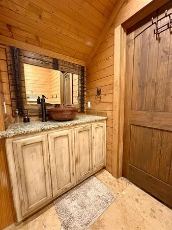 a bathroom with a granite countertop sink and a mirror