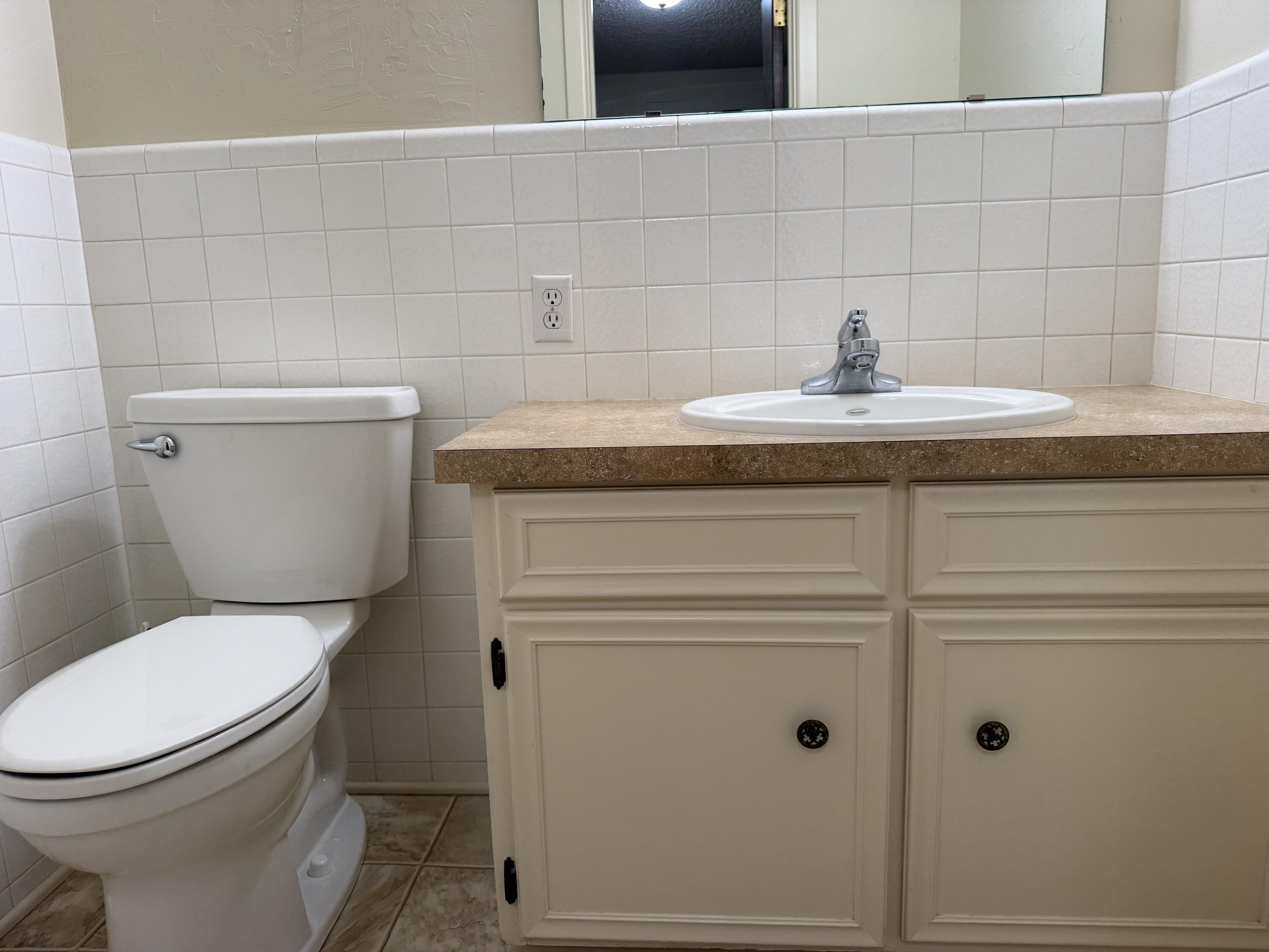 1603 South 8th Street Lamesa, TX 79331 - Photo 30 of 39 a bathroom with a toilet sink and mirror